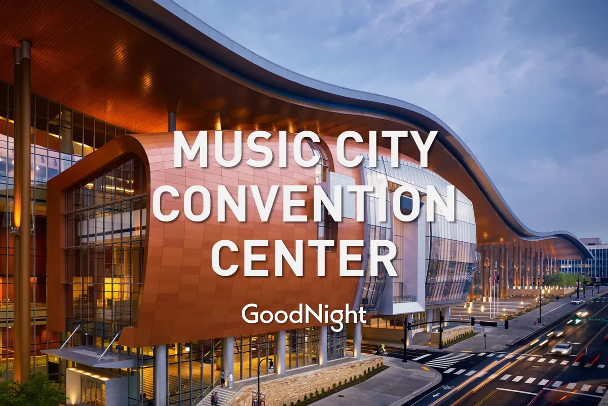 A dynamic view of a modern building with curved architectural lines, large glass windows, and warm lighting. The scene conveys an energetic environment suited for conferences, exhibitions, and community events.