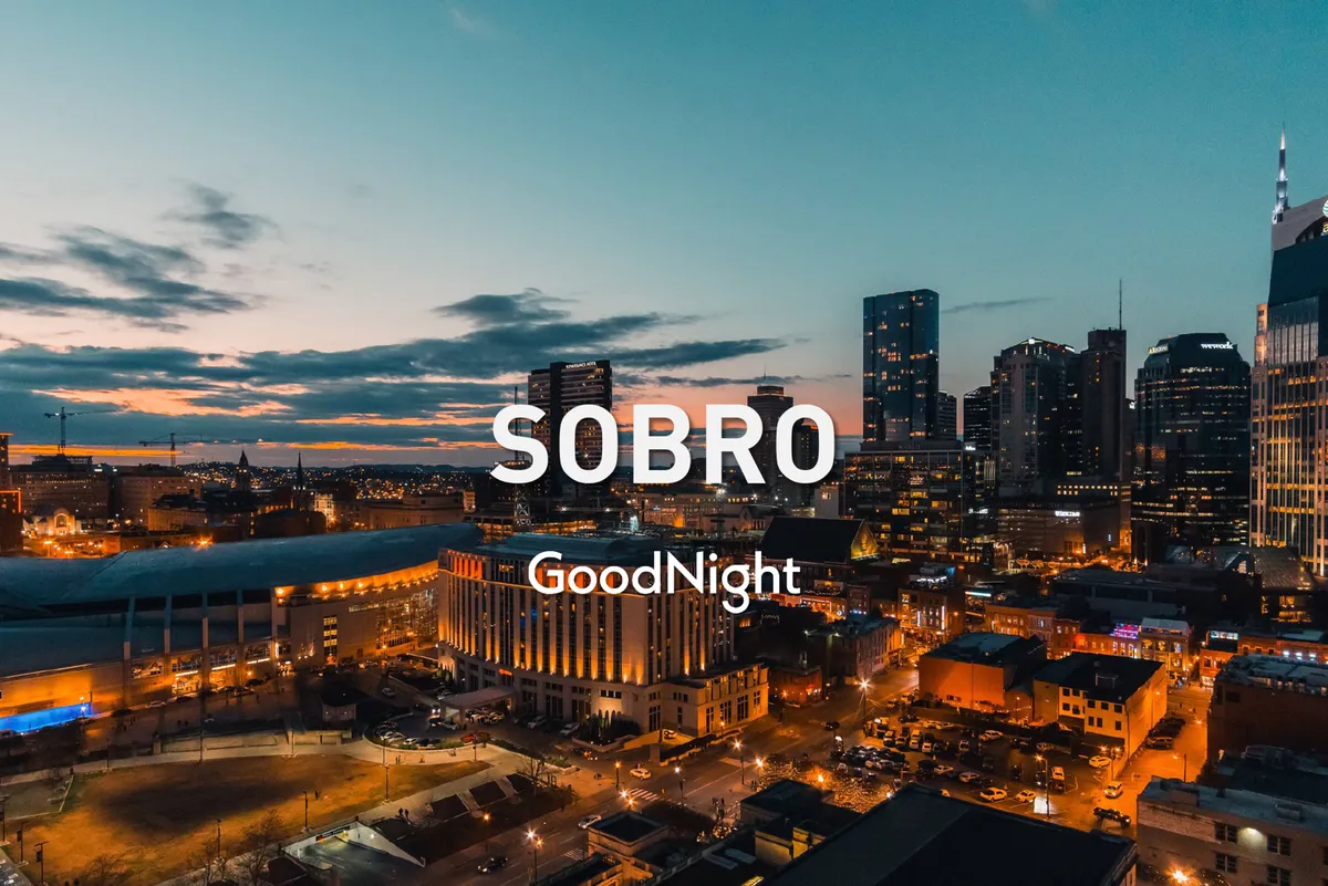A stunning city view at dusk with the Nashville skyline illuminated, streetlights glowing, and buildings lighting up as night falls. The mood is vibrant yet relaxed, hinting at both urban exploration and evening adventures.