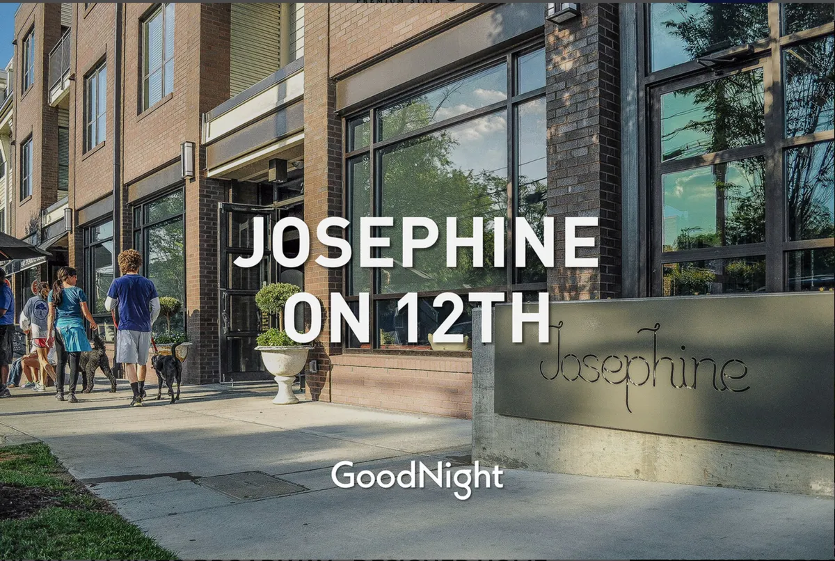 A vibrant exterior scene featuring the building facade, signage, people walking, and planters. The atmosphere is lively and welcoming, highlighting walkable access to local amenities.